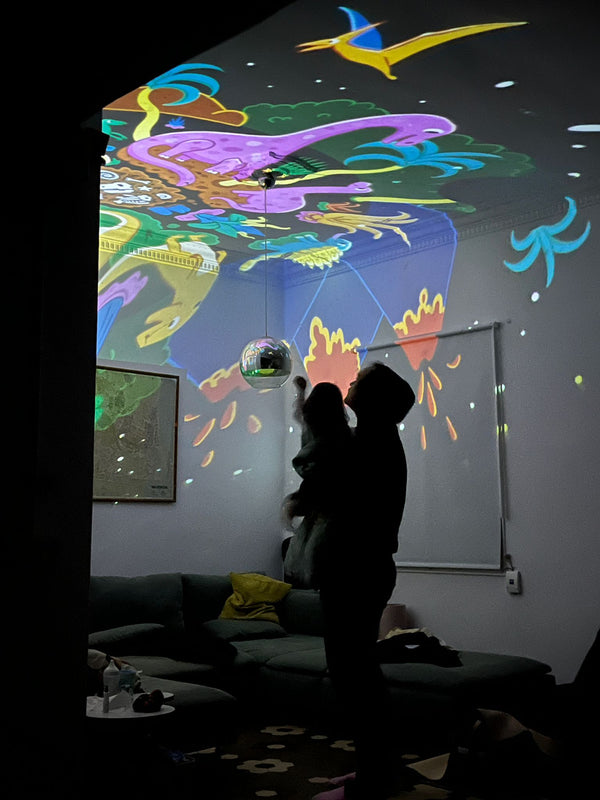 Papa und Kind tauchen gemeinsam in die BiMA Lichterwelt bei den Dinosauriern ein.